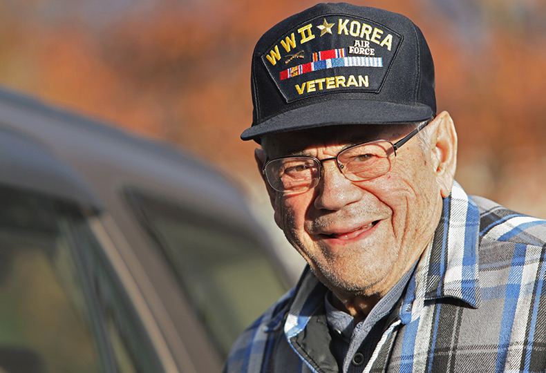 A veteran is wearing a WWII veteran hat.