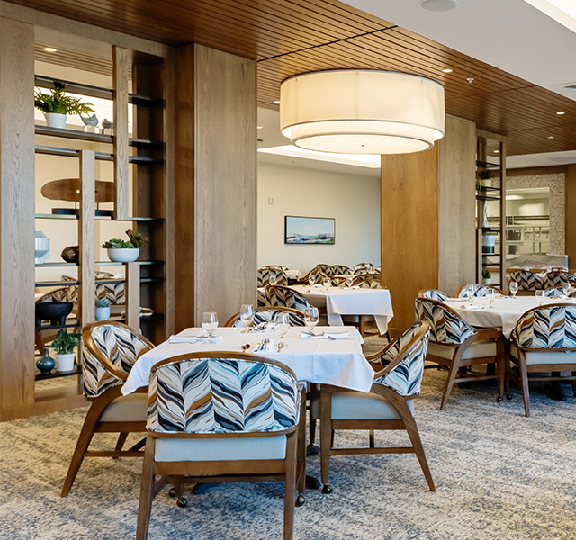 A dining room with tables set for dinner.