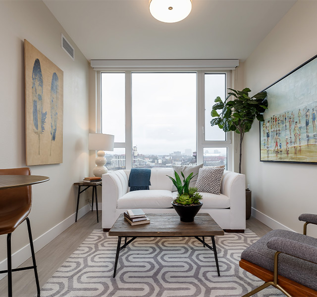 A fully furnished living room with a view out the window.
