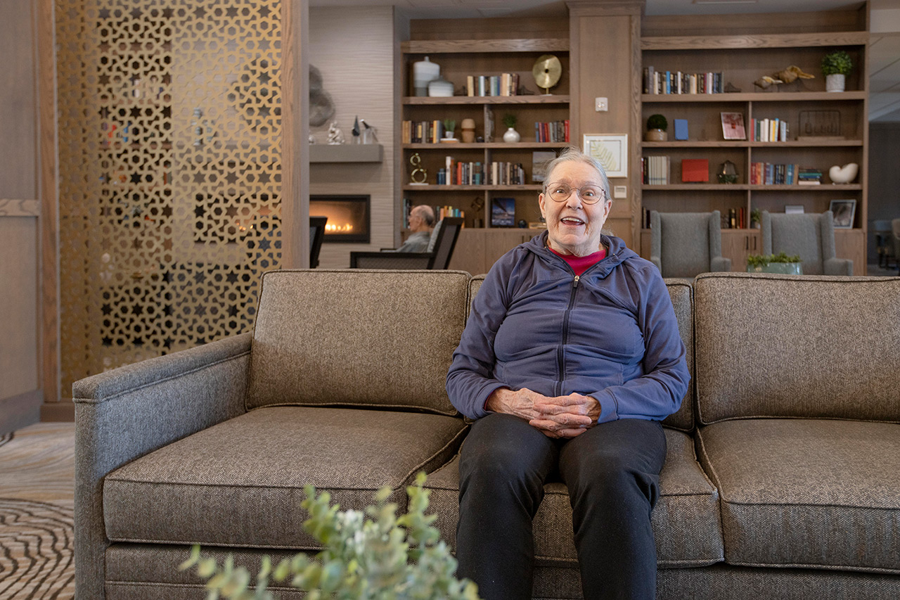 Happy resident sitting on couch.