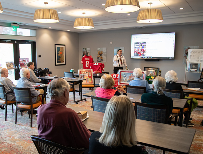 People in a class setting with someone speaking.