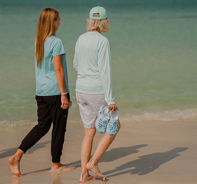 Two people walking on the beach.