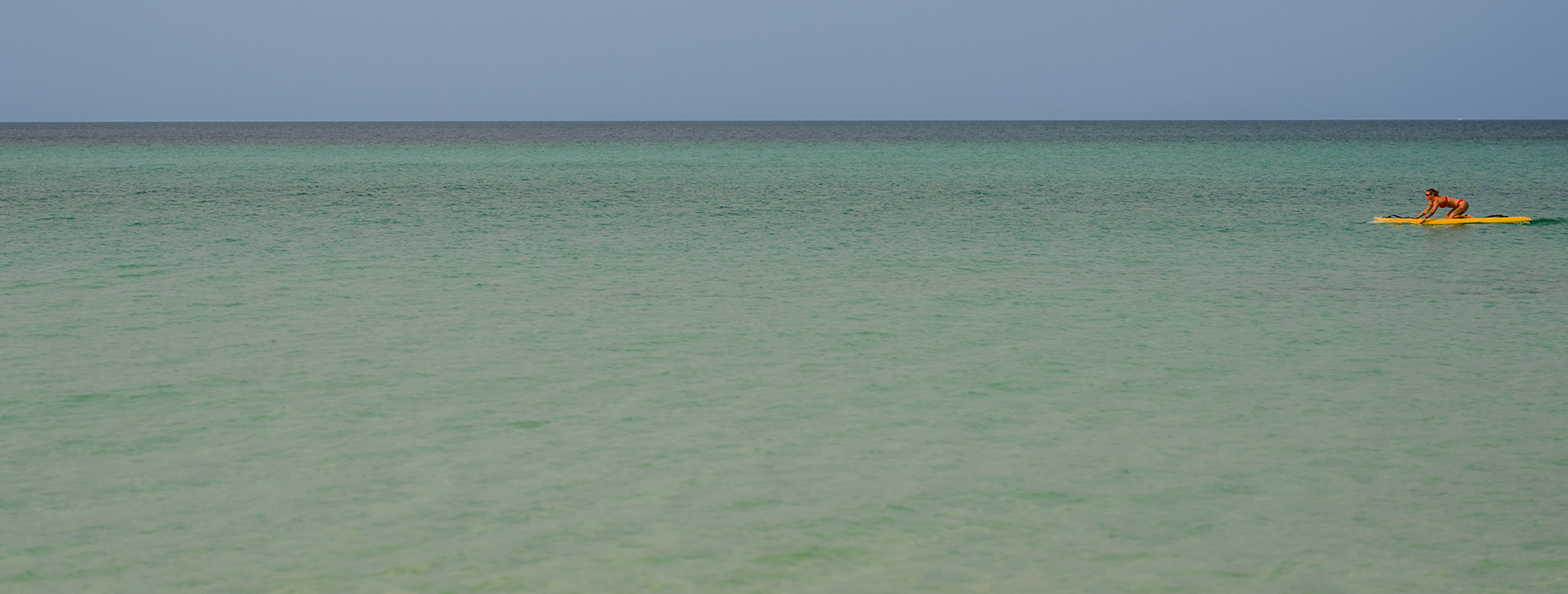 A person on a paddleboard in the ocean.