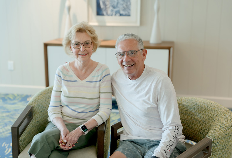 Two people sitting and smiling.