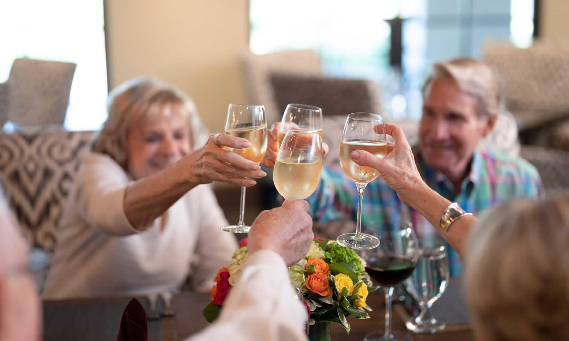 residents raising their glasses to toast over a meal