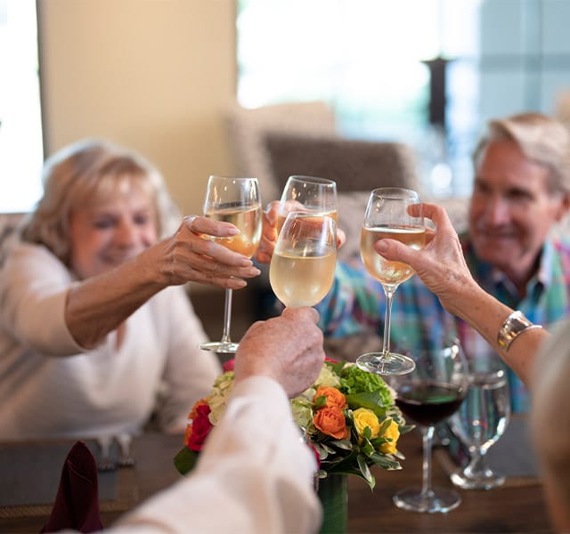 residents raising their glasses to toast over a meal