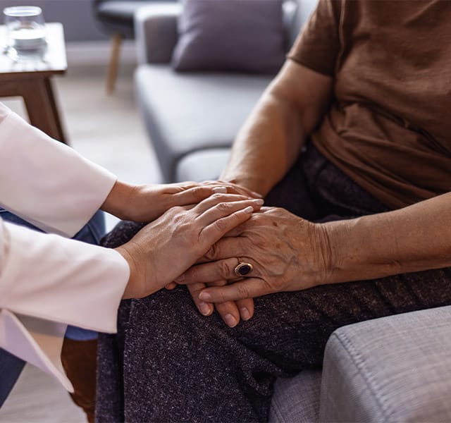 Cropped shot of a person holding hands with a hospice nurse