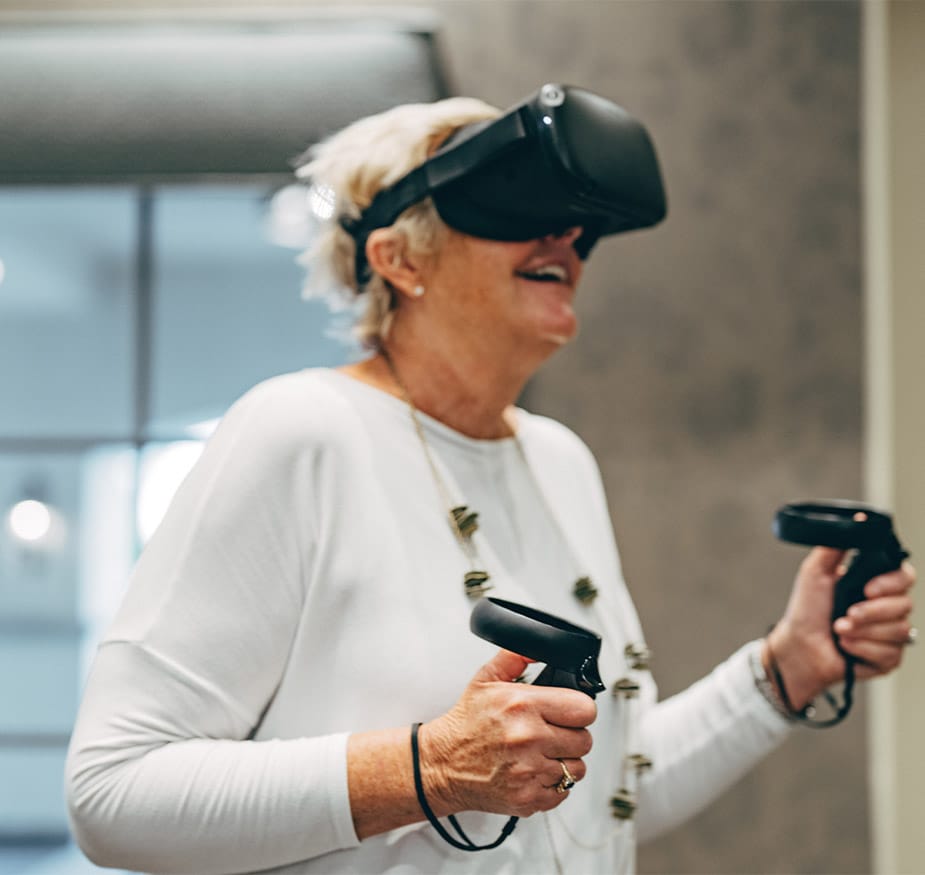 Residents enjoying virtual reality wearing goggles and holding controls.