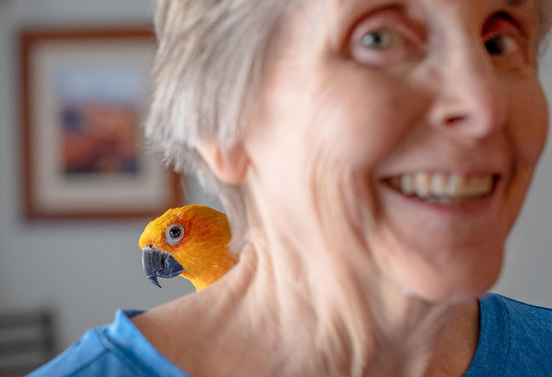A resident with a parrot on their shoulder.