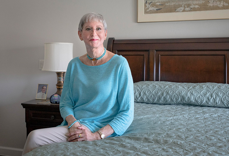 A smiling resident sitting on the bed