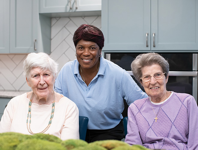 Two residents are with a caregiver.