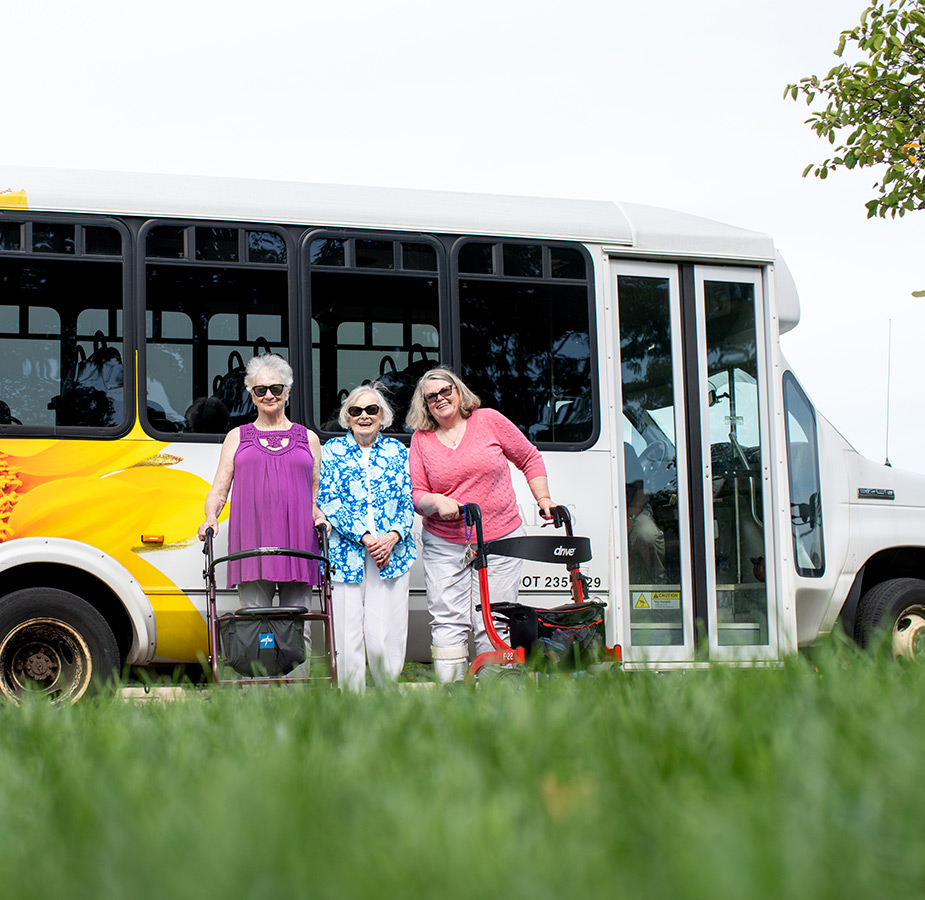 Three residents are standing by a bus.