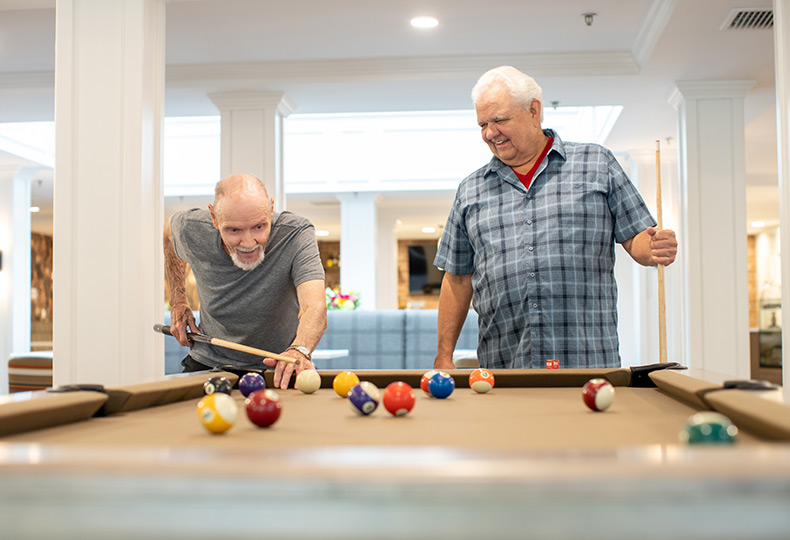 Two residents are playing pool.