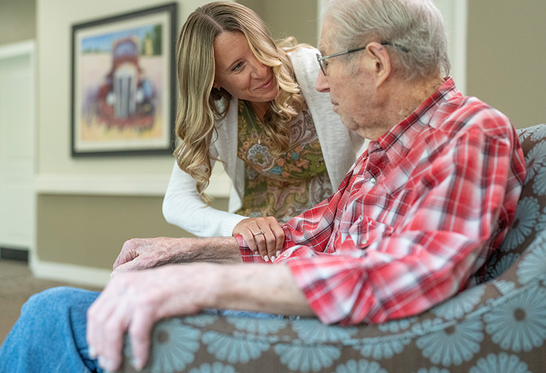 A resident is talking with their caregiver.