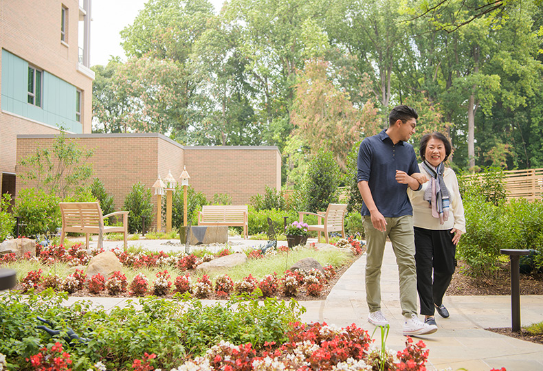 A resident is walking with a family member.