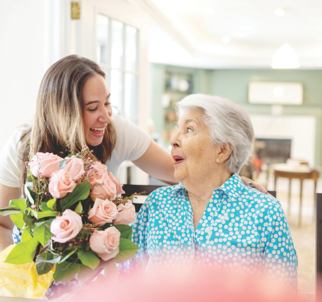 Two women laughing at table.