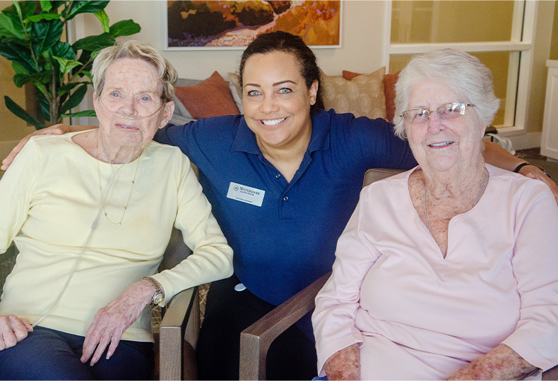 Three people sitting and smiling.
