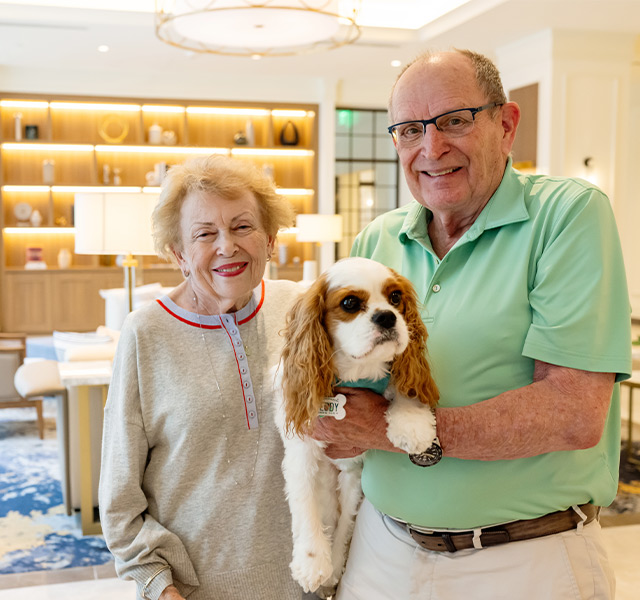 A couple holding their dog.