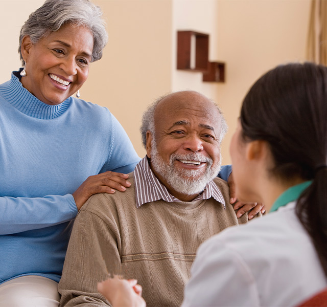 Two people talking with a caregiver.