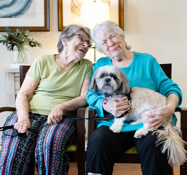 Two people with a dog on the couch.