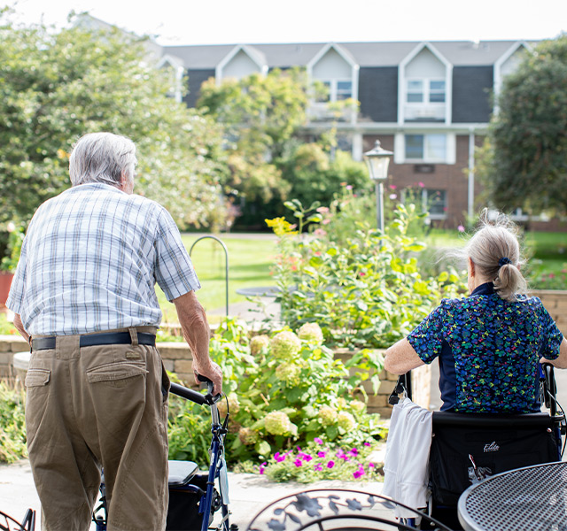 Two people walking in a garden.