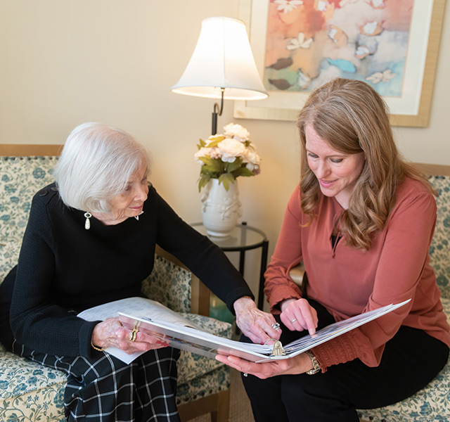A resident showing a photo album to a family member.