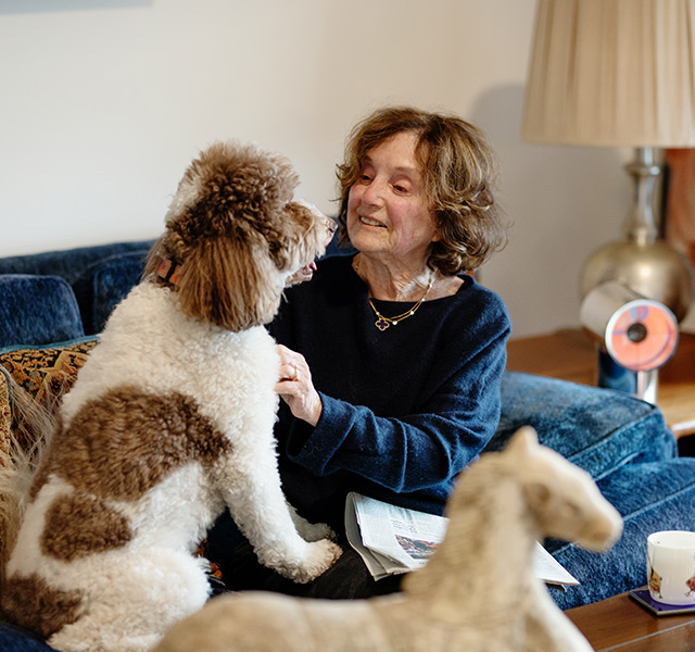 A person on the couch with their dog.