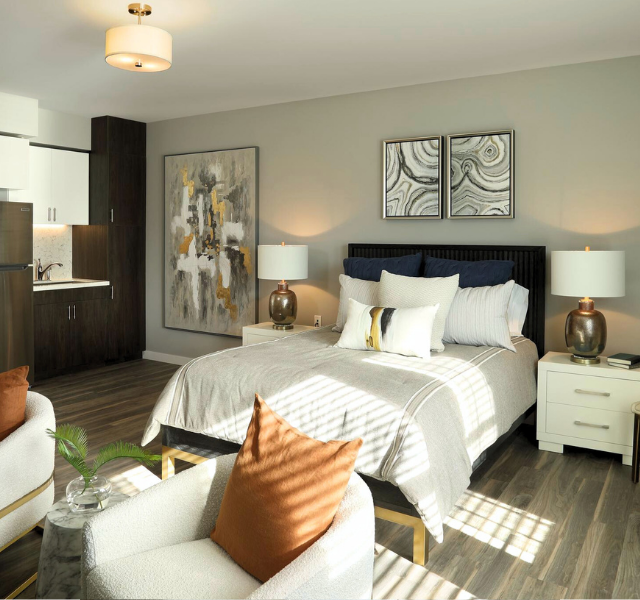 Studio apartment with bed, kitchenette, and chairs