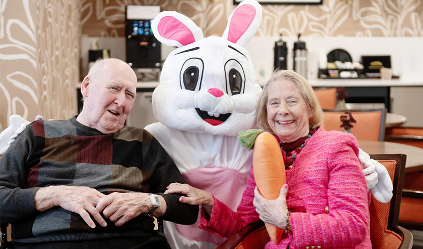 A large bunny with two people smiling.