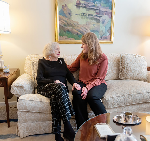 Two people talking on the couch.