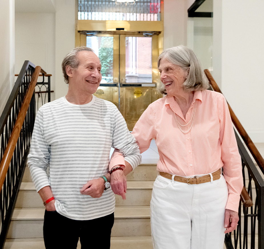 Two people walking down stairs.