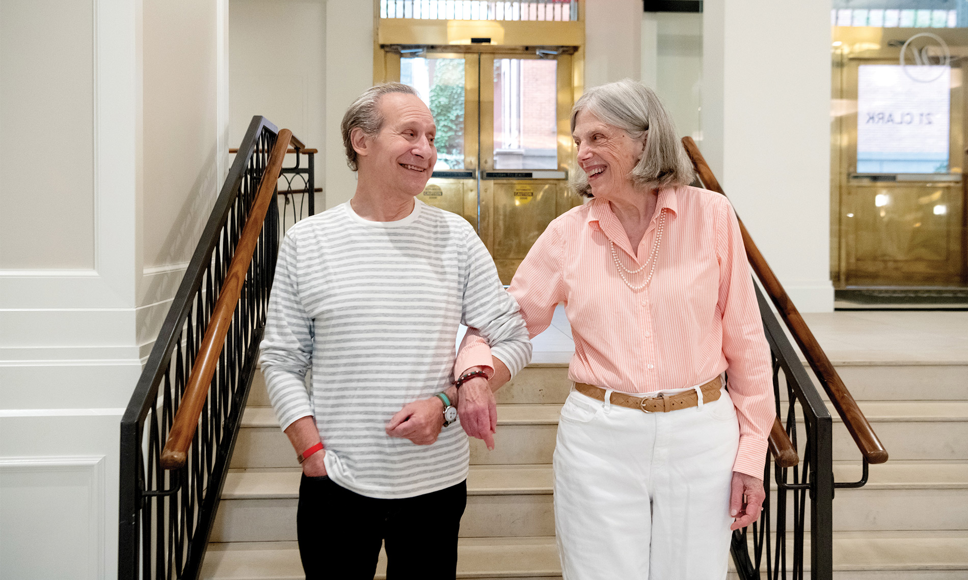 Two people walking arm in arm.