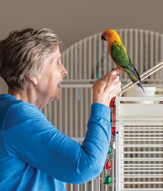 A person with a bird on their finger.