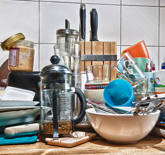 A pile of dishes on the counter.