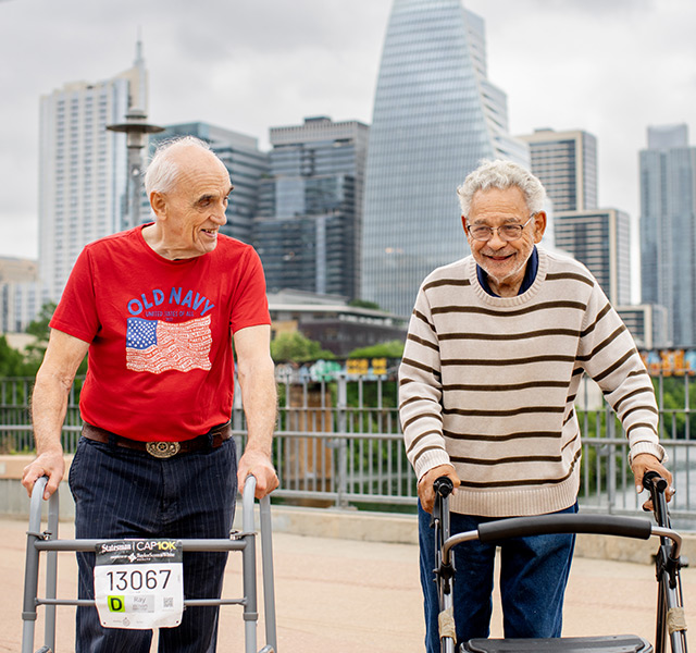Two friends walking with walkers.