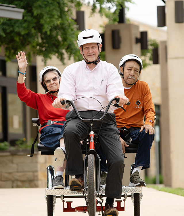 Three people on a bicycle.