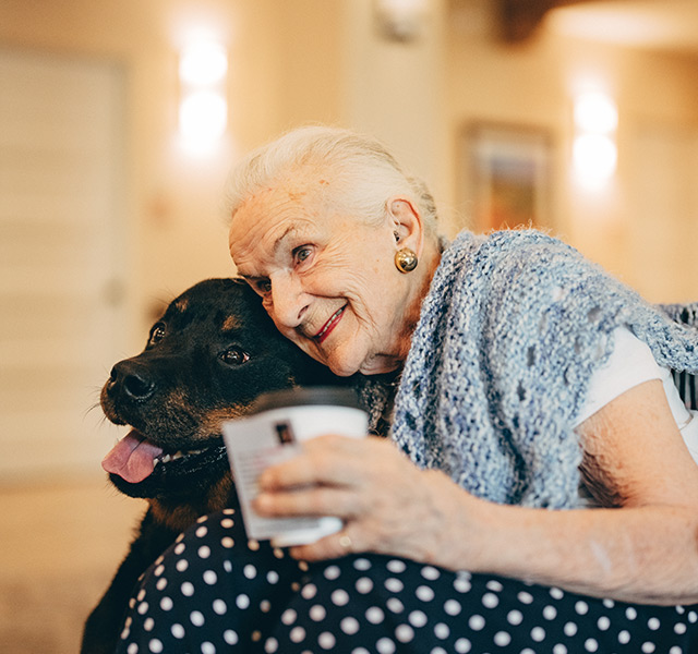 A resident is hugging a dog.