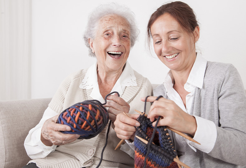 Two people with knitting yarn.