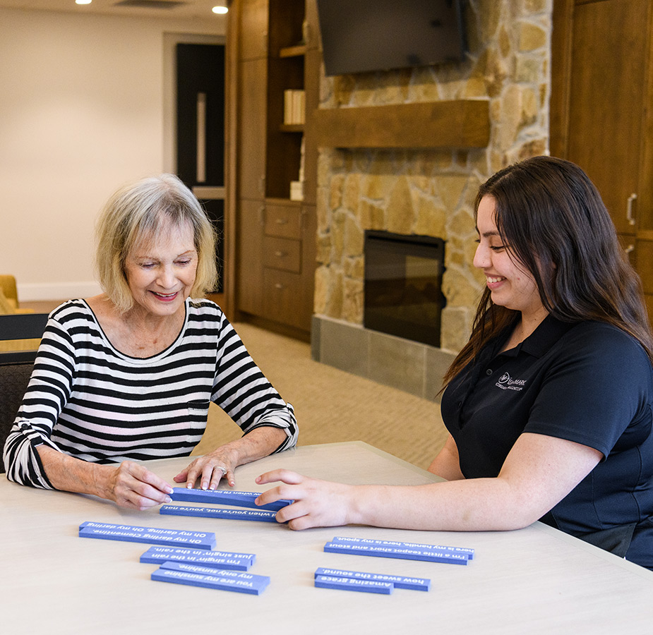 A resident and a caregiver are working on an activity together.