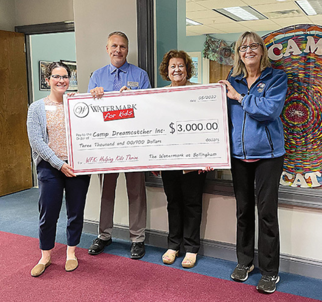 Four people holding check for Camp Dreamcatcher