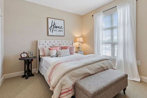 Bedroom with bed by a window.