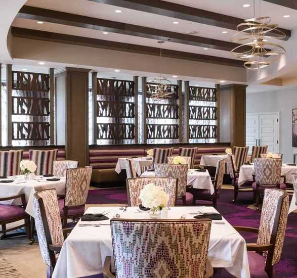 The Preston of The Park Cities dining area with set tables and white tablecloths