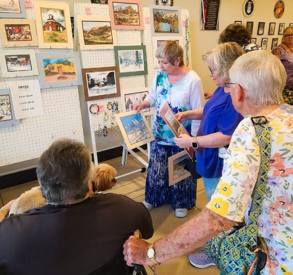 Residents at an art show gathered around a few paintings.