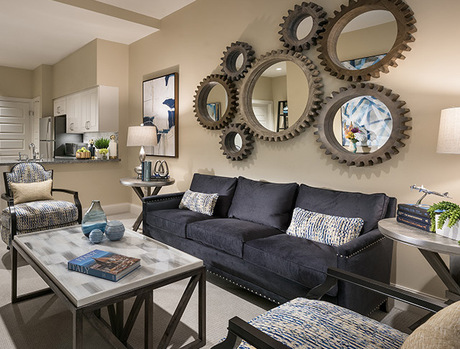 A fully furnished living room with tones of blue, gray and tan.