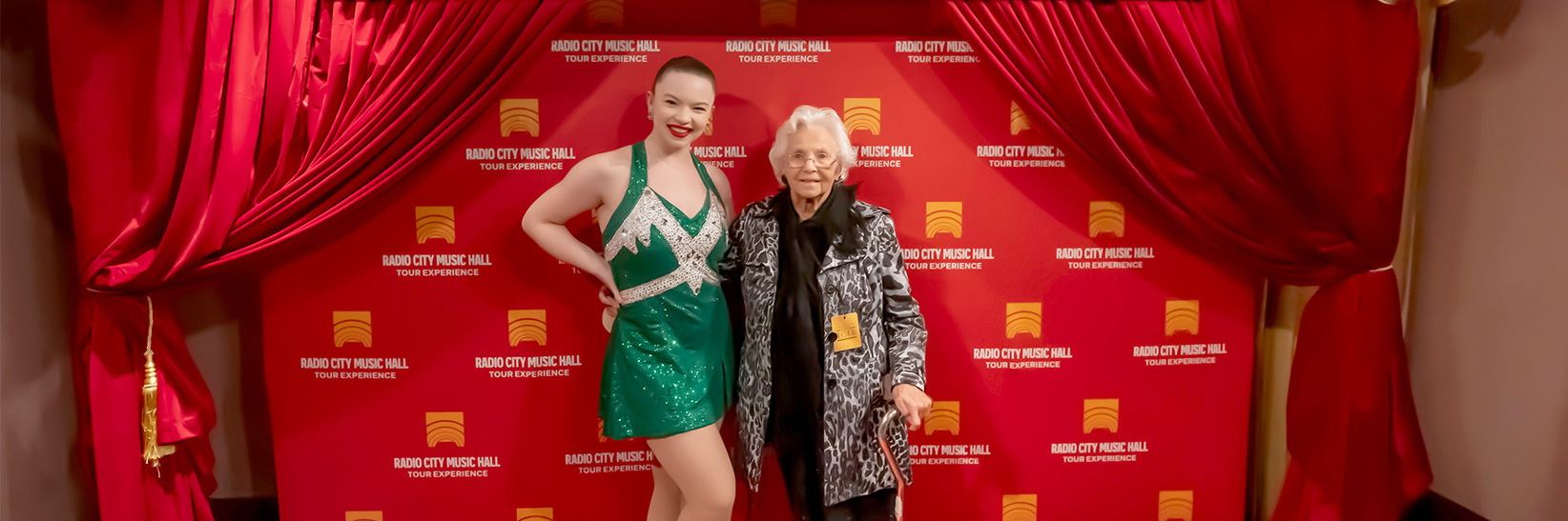 A person standing with a Rockette. A person standing with a Rockette.