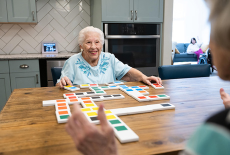A memory care resident is playing a game in the activity room at East Village Place in East Longmeadow.