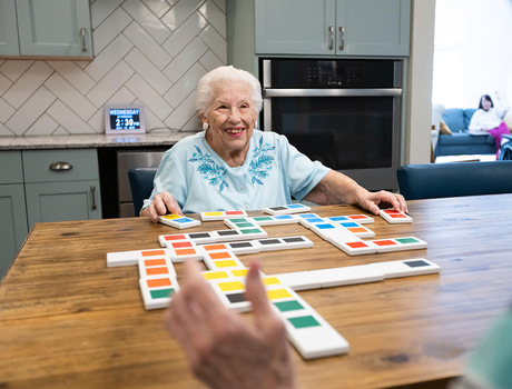 A memory care resident is playing a game in the activity room at East Village Place in East Longmeadow.