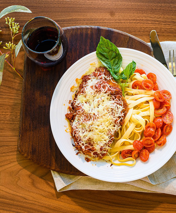 A plate of spaghetti and a glass of wine.