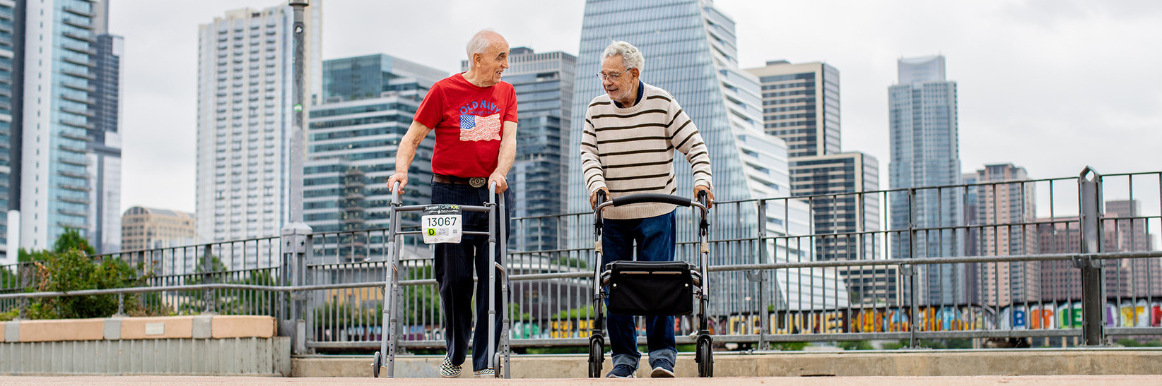 Two residents walking with the city of Austin behind them.