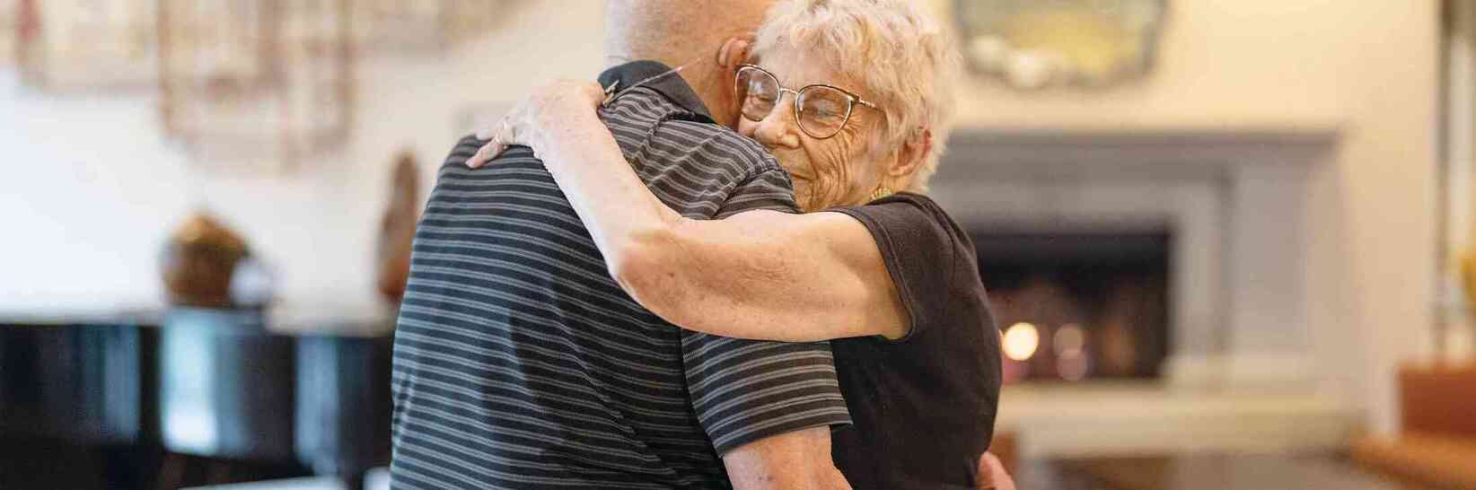 Two residents dancing close together in the lounge. Two residents dancing close together in the lounge.